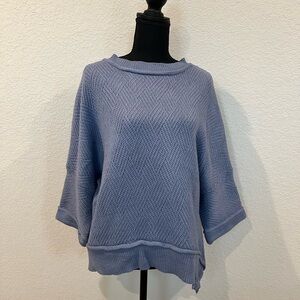 Blue oversized crew neck sweater with wide sleeves and layered hem